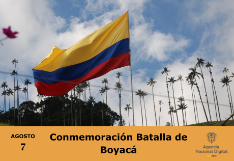 La bandera de Colombia ondeando al viento frente a un paisaje de palmas y cielo despejado, conmemorando la Batalla de Boyacá.