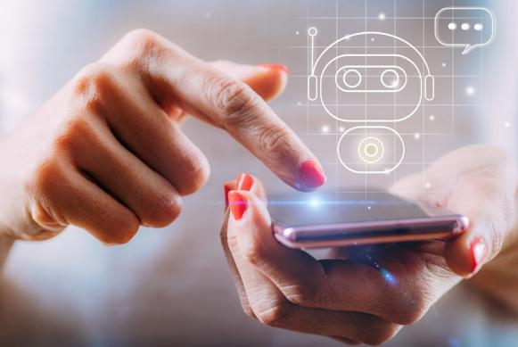 Imagen de manos de una mujer manipulando un celular con su dedo indice dónde se proyecta una imagen holográfica de un robot de inteligencia artificial.